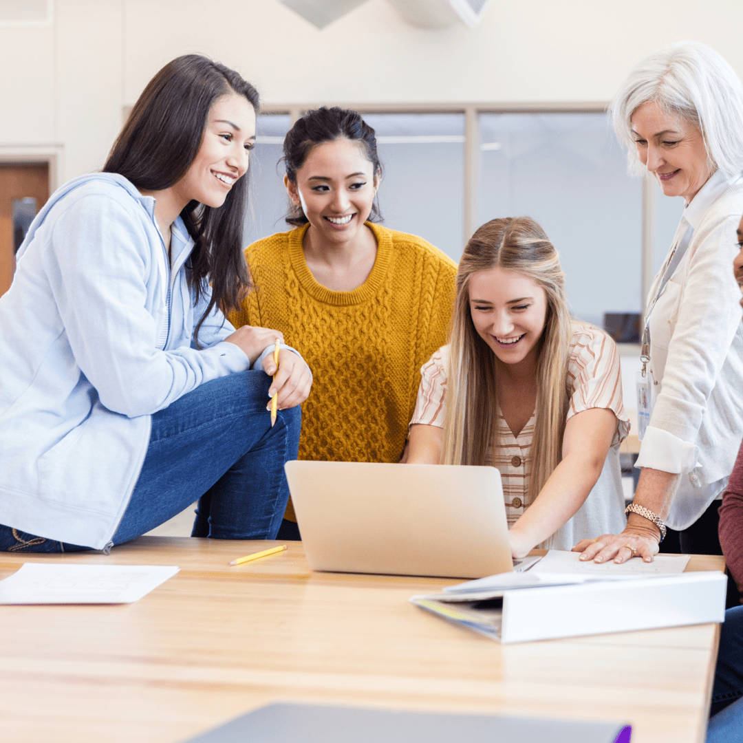 Group of diverse professionals collaborating on laptops in modern workplace; Train everyone, everywhere with SimpliTrain LMS