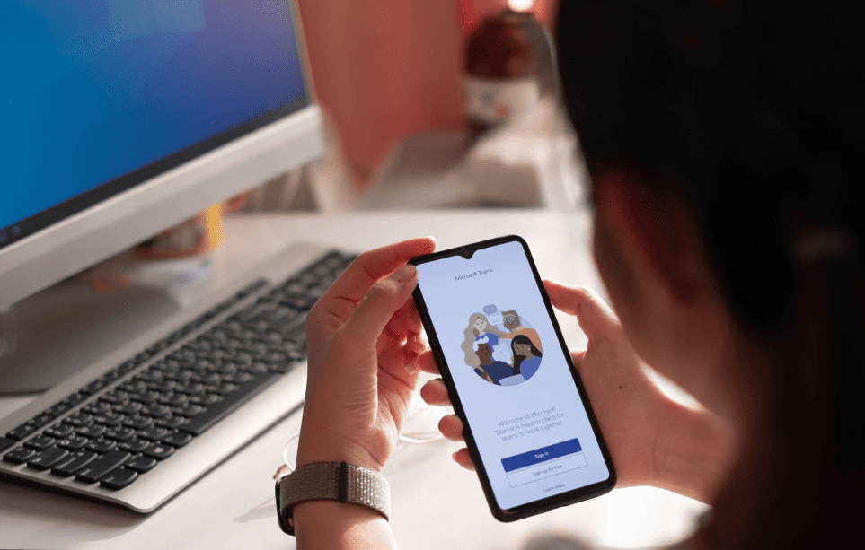 Person using mobile app in front of desktop smart Integrations all-in-one-place